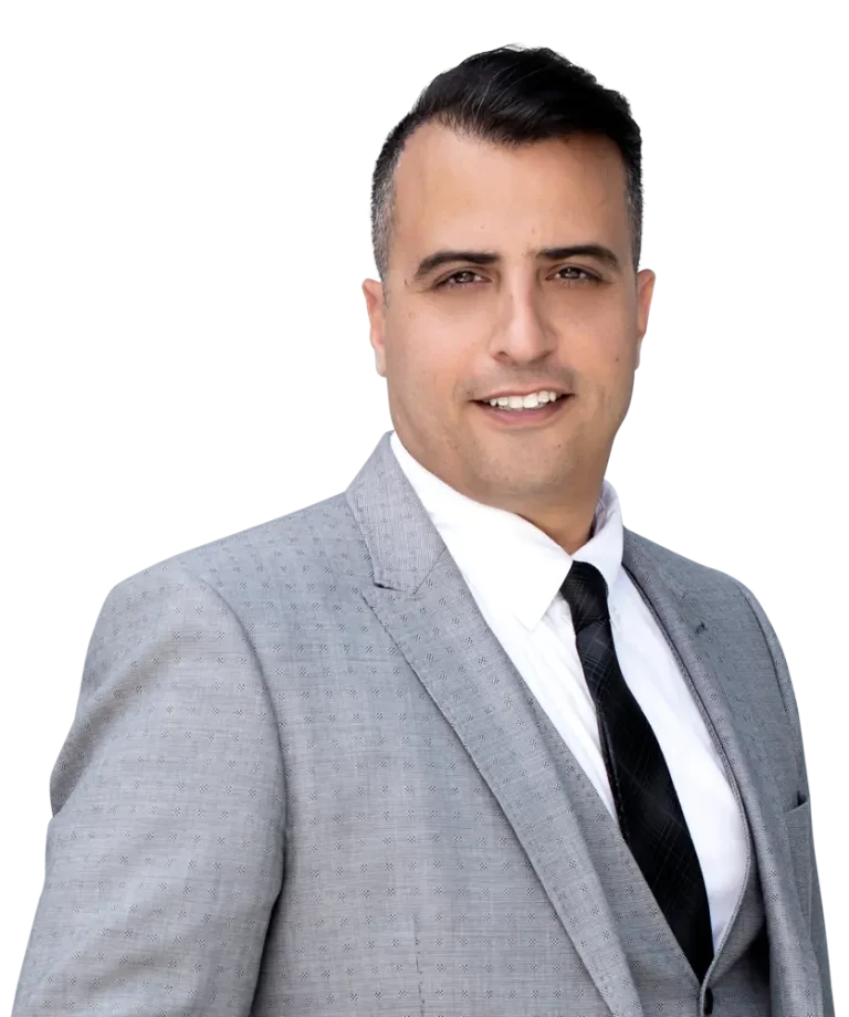 Man in a light gray suit with a black tie, smiling at the camera.