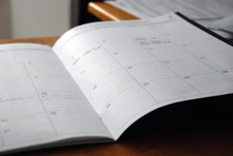 Open planner showing a monthly calendar on a desk.