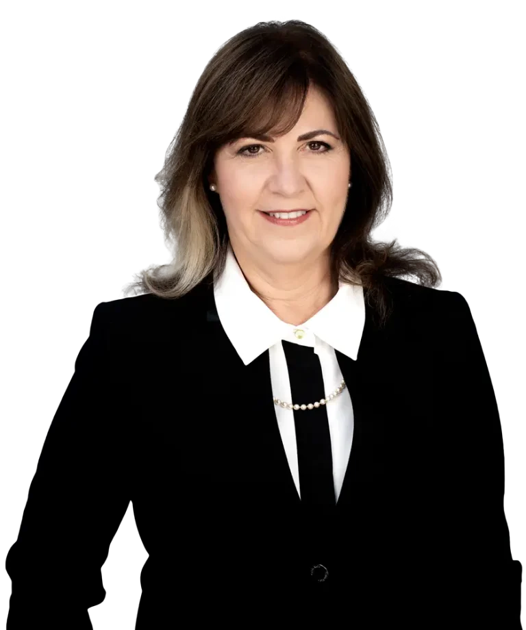 Woman in business attire smiling against a plain background.