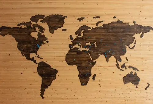 Wooden world map with countries outlined in dark wood.