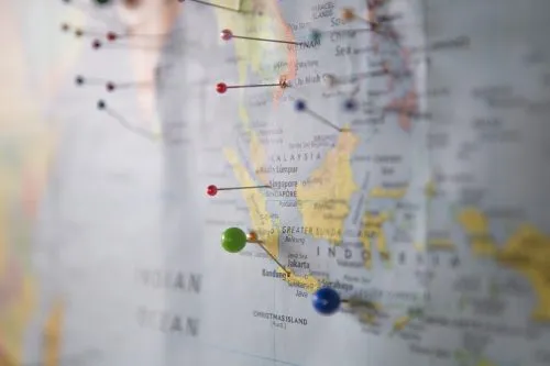 Close-up of a map with colorful pins marking various locations.