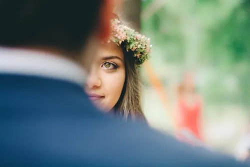 Woman with flower crown partially visible behind another person.
