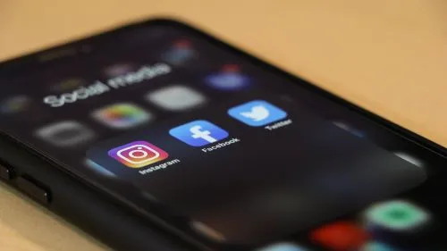 Smartphone screen displaying Instagram, Facebook, and Twitter app icons.