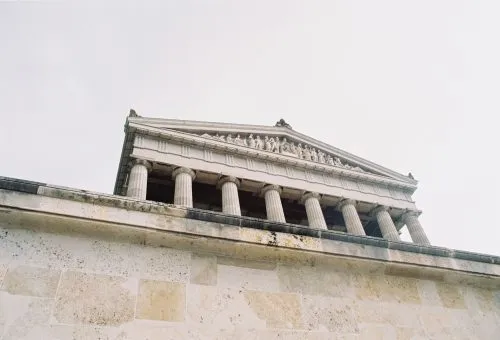 Low-angle view of a neoclassical building with columns and a detailed frieze.