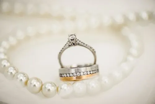 Diamond and gold rings set against a string of pearls.